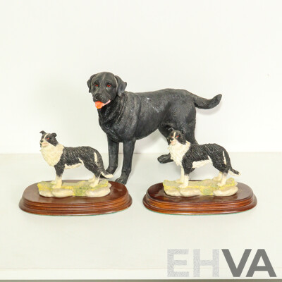 Three Resin Dog Figurines: Border Collies on Wooden Bases and a Labrador