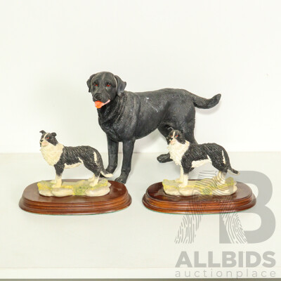 Three Resin Dog Figurines: Border Collies on Wooden Bases and a Labrador