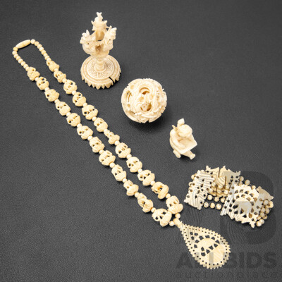 Collection of Carved Bone Items Including Puzzle Ball on Stand, Putti, Elephant Themed Necklace and More