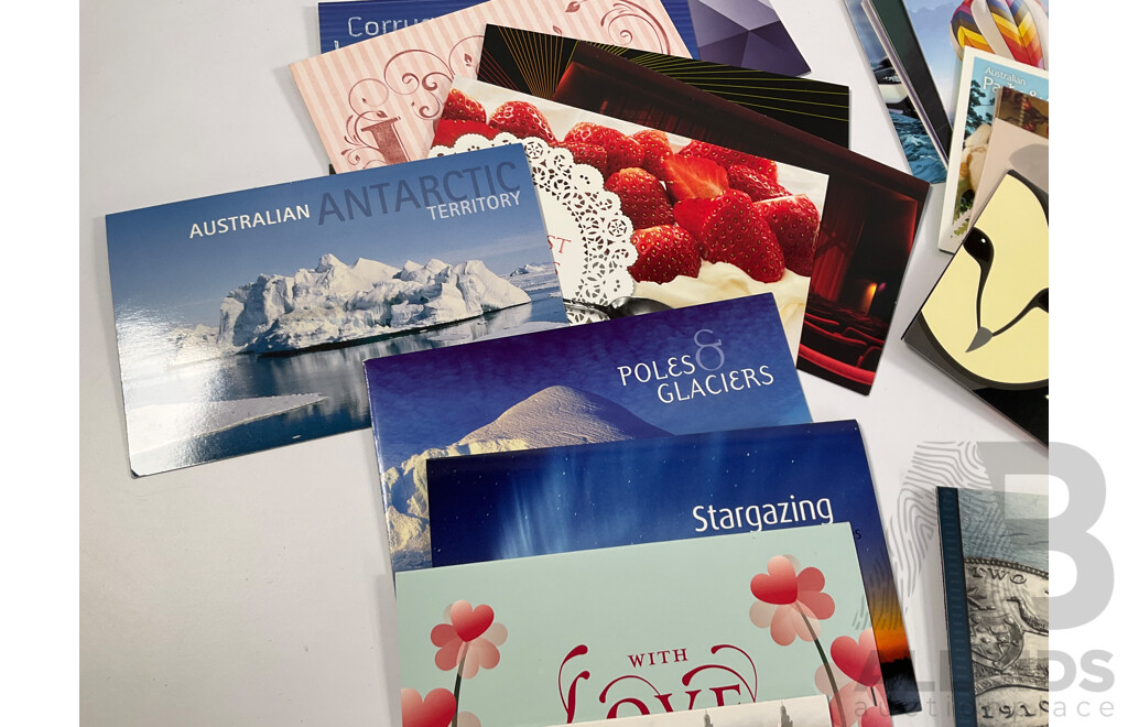 Fifty Six Australian Mint Stamp Packs Including Queensland 150 Years, Stargazing, Species at Risk, with Love, Beijing 2008, Gorgeous Australia, Living Green, Australian Commonwealth Coinage and More Face Value Approximately $217